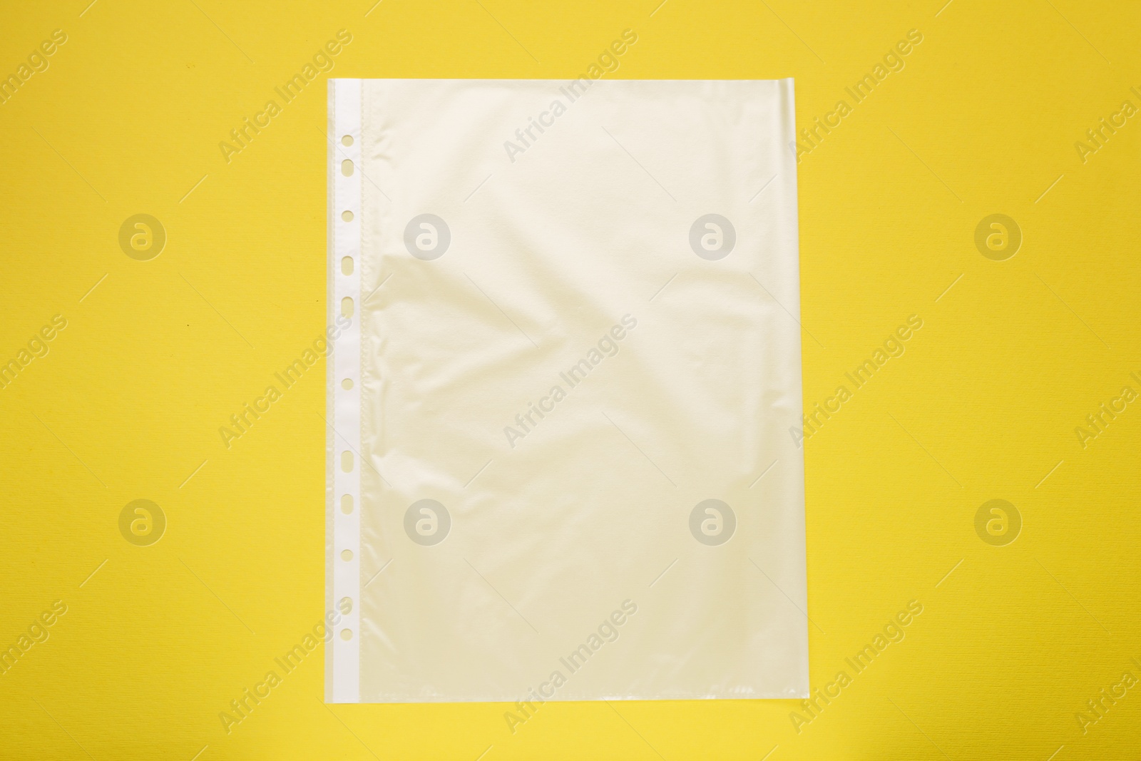 Photo of Punched pocket on yellow background, top view