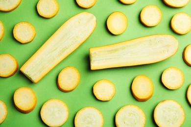 Photo of Fresh ripe cut zucchinis on green background, flat lay