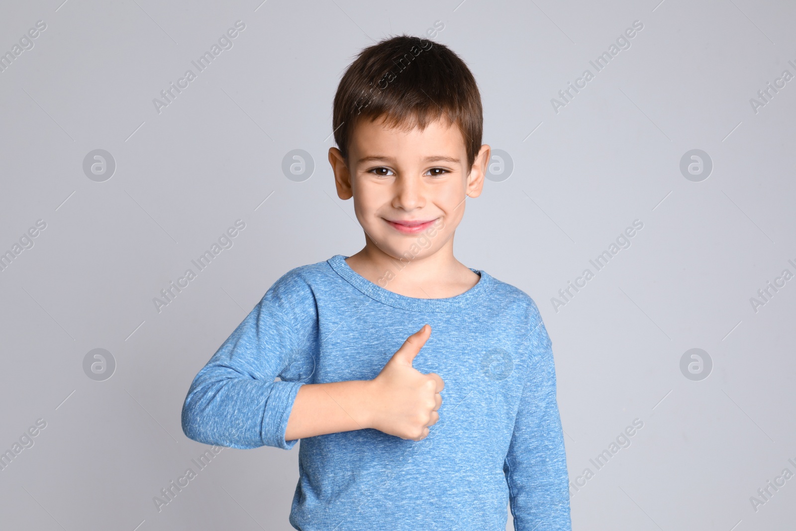 Photo of Portrait of happy little boy on light grey background