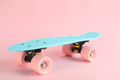 Photo of Turquoise skateboard on pink background. Sport equipment