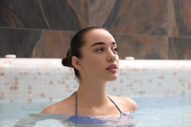 Beautiful woman relaxing in spa swimming pool
