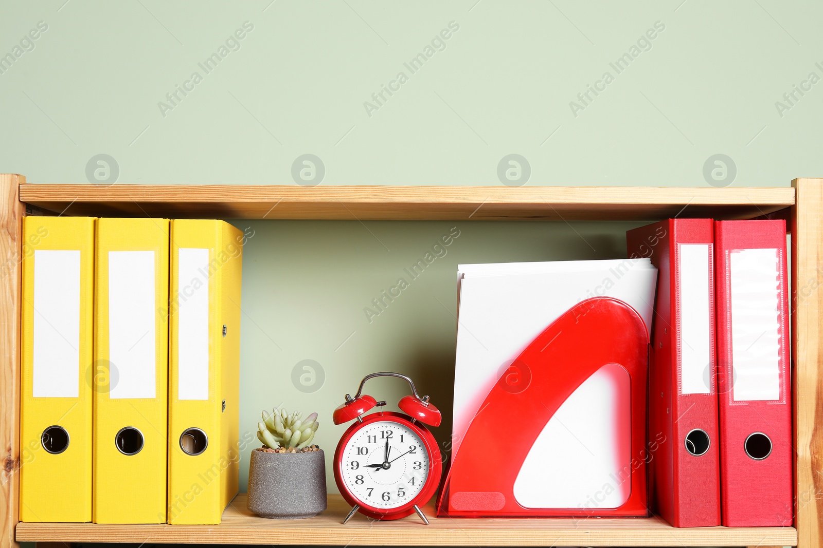 Photo of Colorful binder office folders and stationery on shelving unit indoors