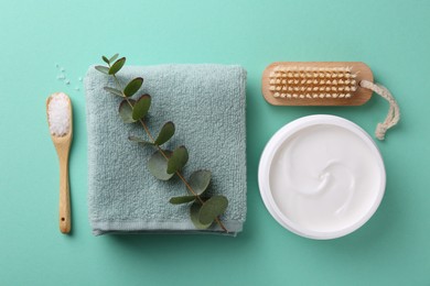 Jar of cream, body care products and eucalyptus branch on turquoise background, flat lay