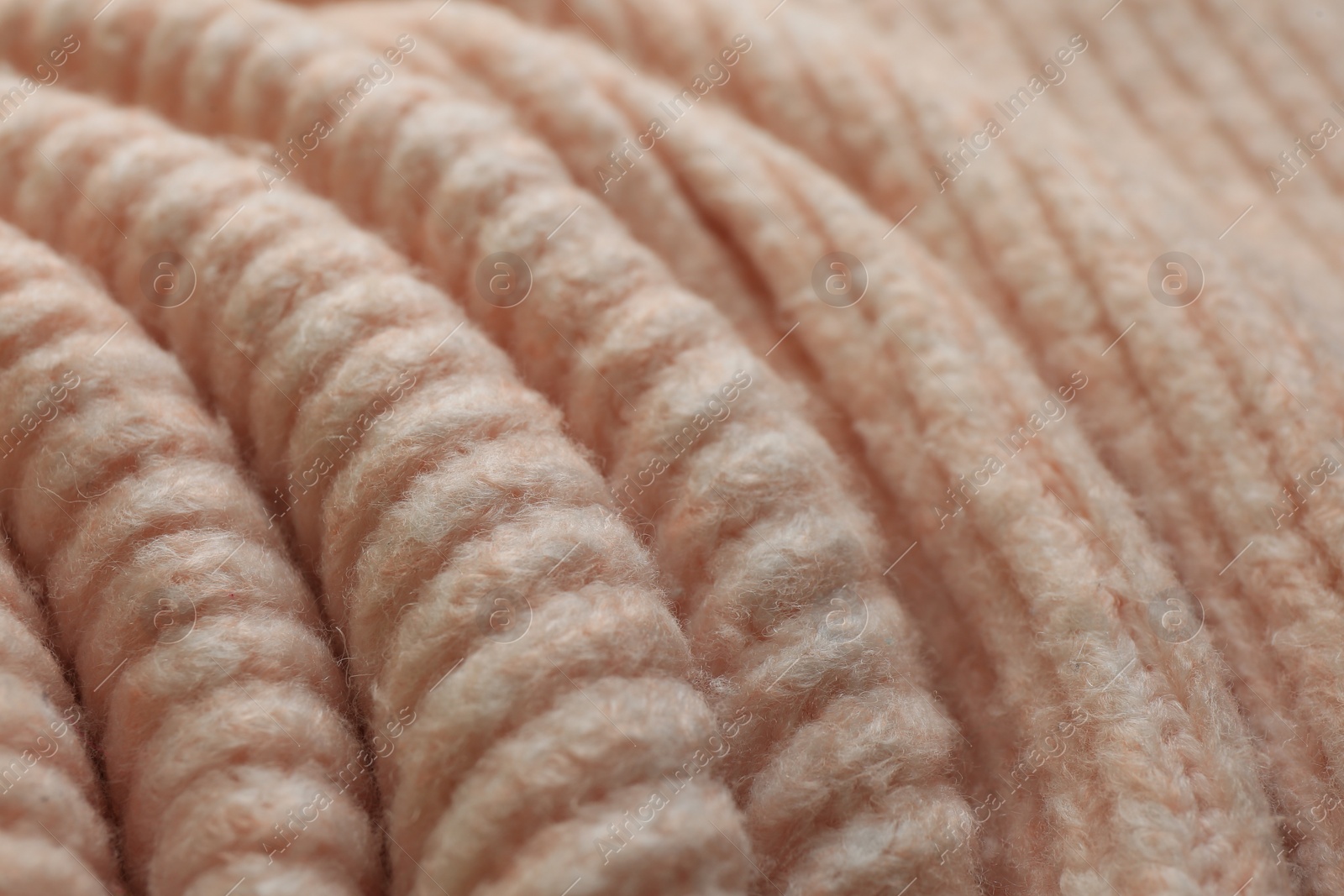 Photo of Beautiful pale pink knitted fabric as background, closeup