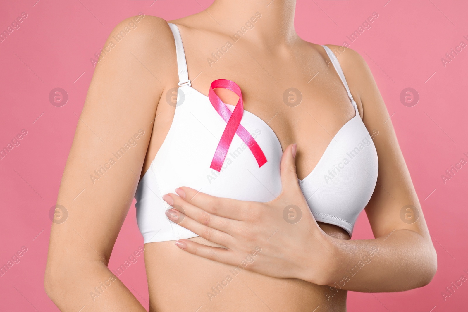 Photo of Woman with pink ribbon on color background, closeup. Breast cancer awareness