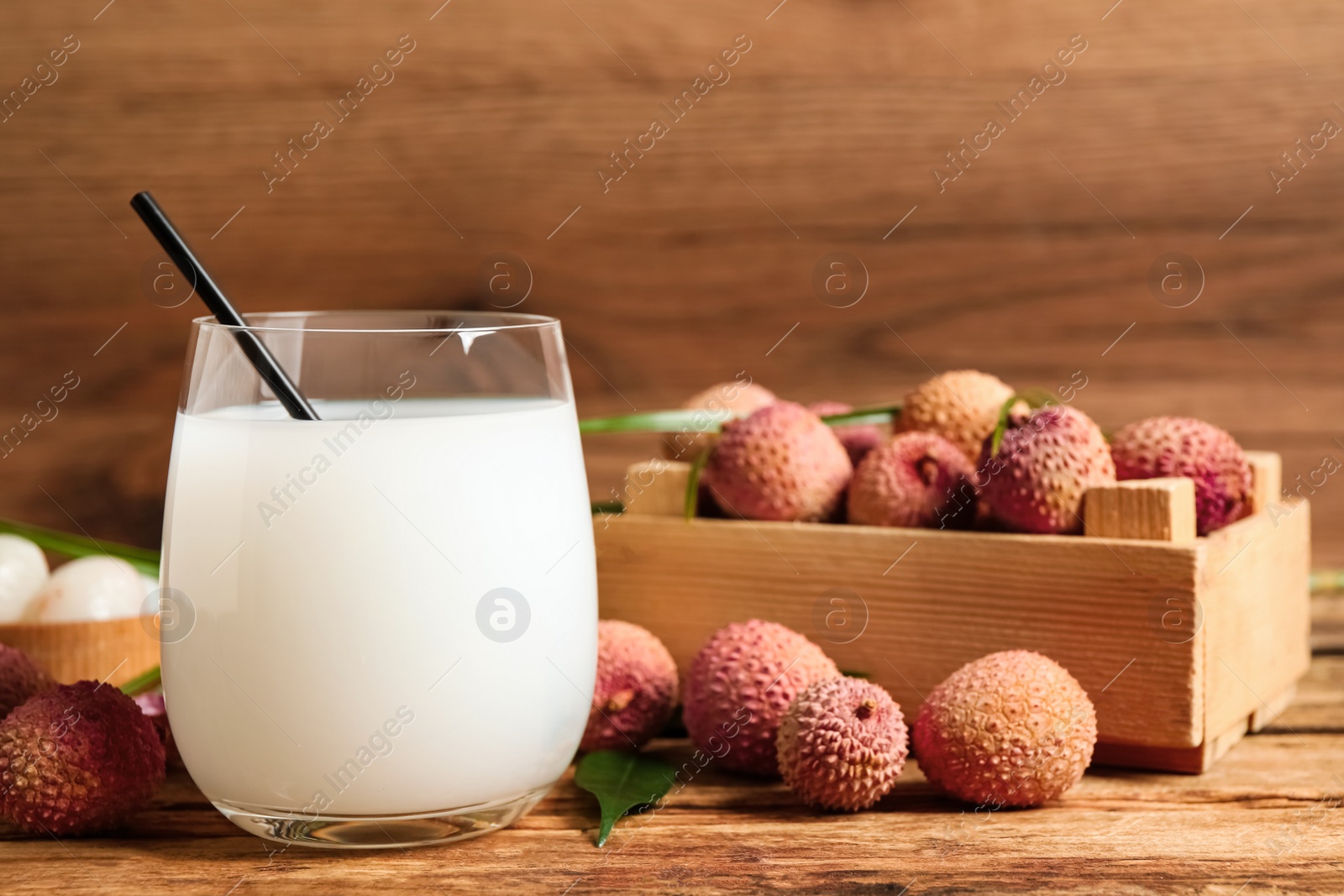 Photo of Lychee juice and fresh fruits on wooden table