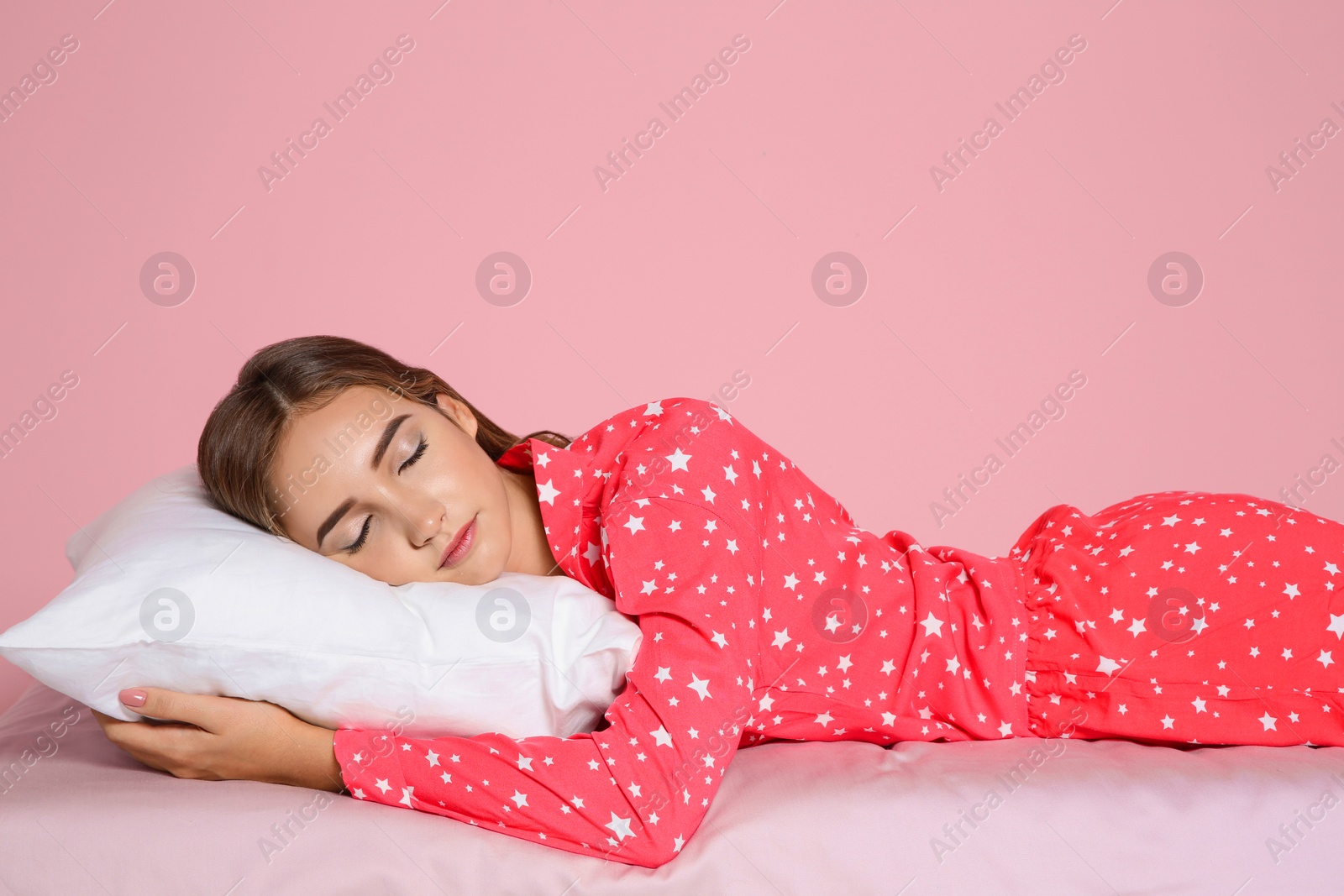 Photo of Beautiful teen girl sleeping with comfortable pillow on bed against color background