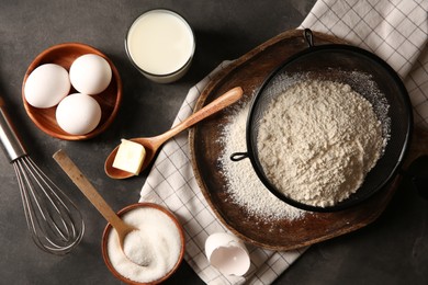 Photo of Different ingredients for dough on grey textured table, flat lay