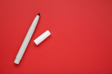 Photo of Grey marker on red background, flat lay. Space for text