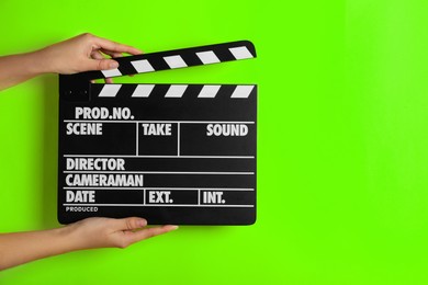 Image of Second assistant camera holding clapper board against chroma key background, closeup. Space for text