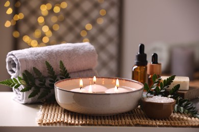 Beautiful composition with different spa products on table against blurred lights