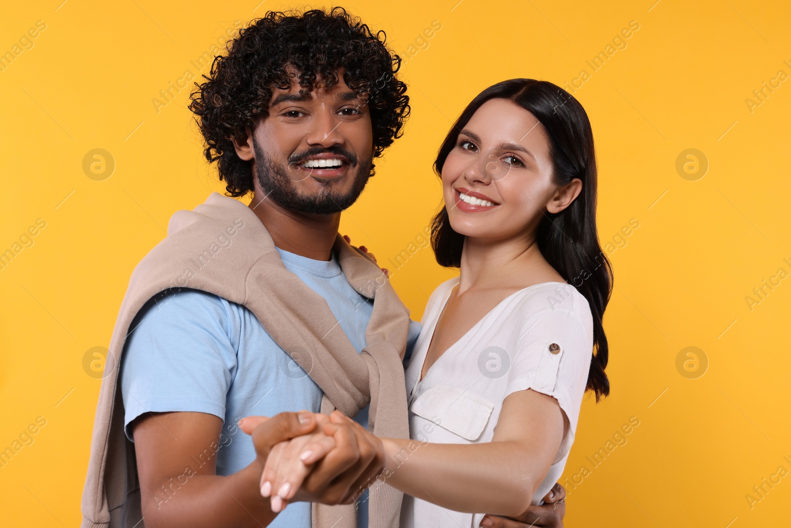 Photo of International dating. Happy couple dancing on yellow background