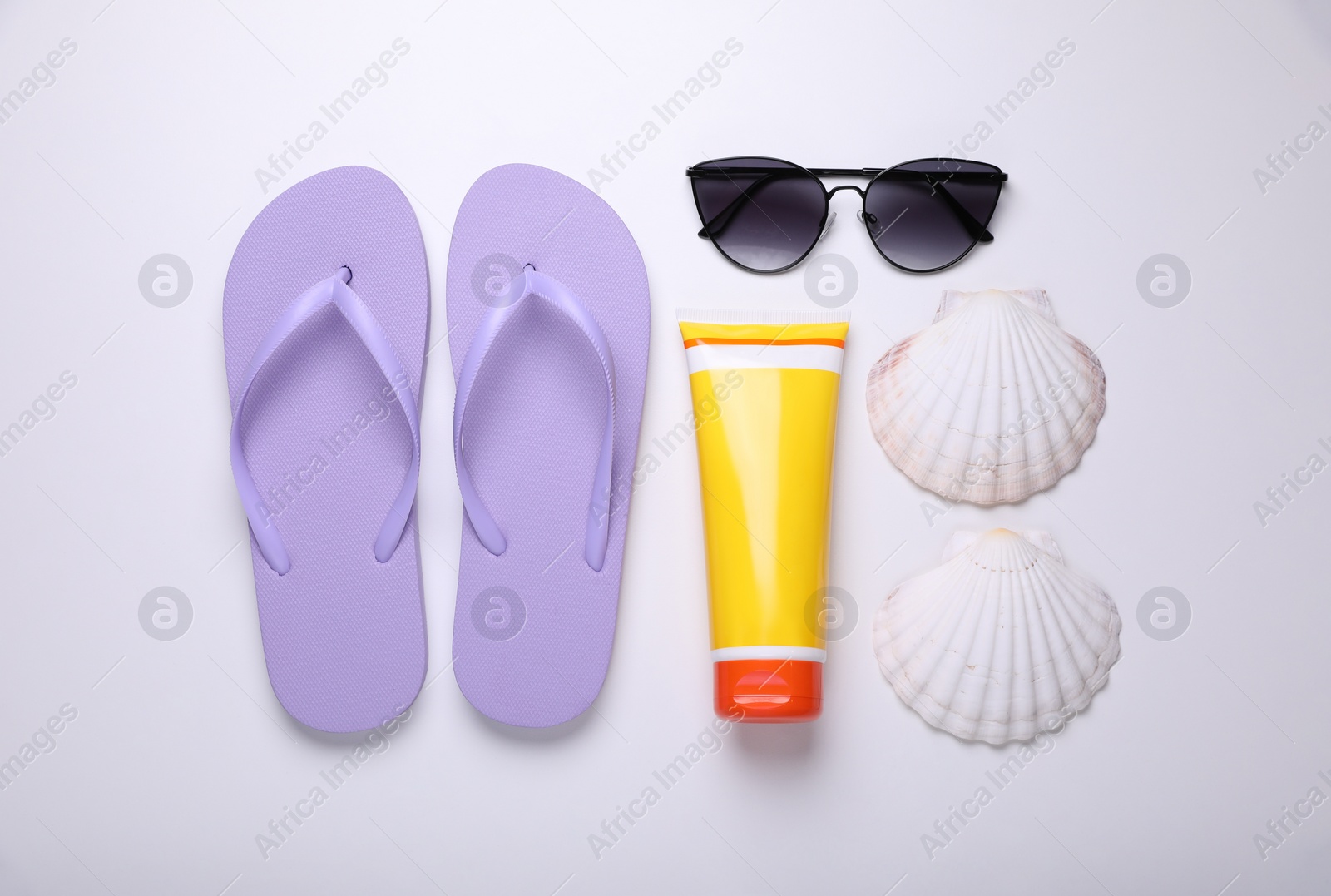 Photo of Flat lay composition with sunscreen and beach accessories on white background