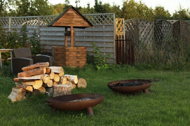 Pile of cut firewood on green grass in backyard