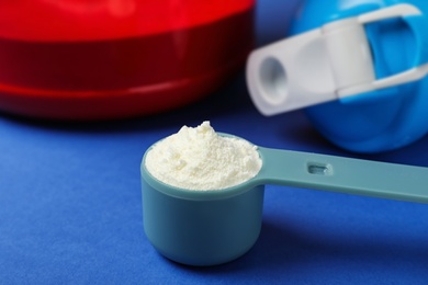 Measuring scoop with protein powder on table