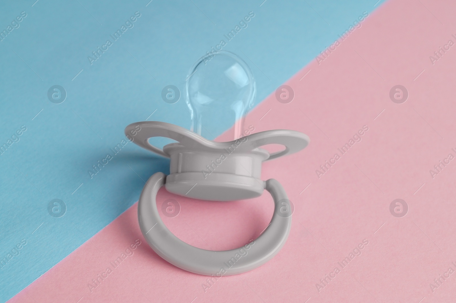 Photo of New baby pacifier on color background, closeup