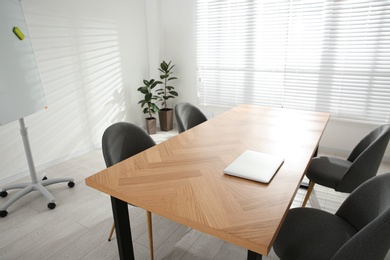 Conference room interior with laptop on wooden table