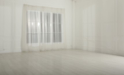 Empty room with white walls and large window, blurred view