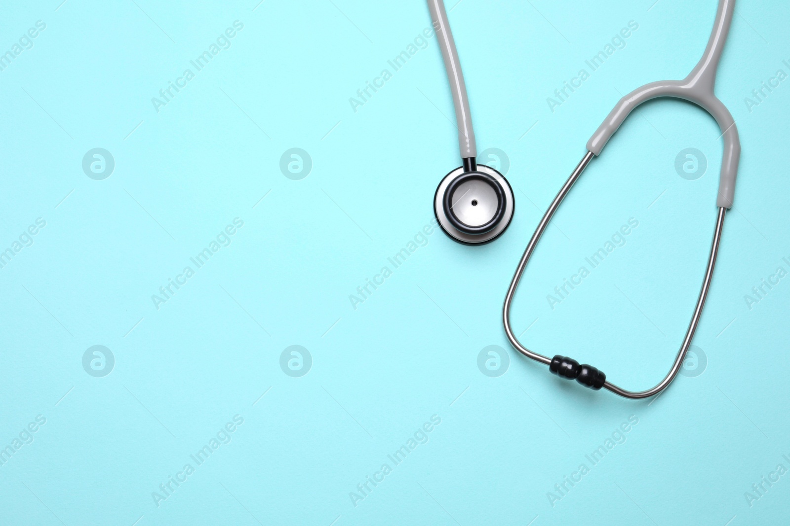 Photo of Stethoscope on light background, top view. Space for text