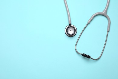Stethoscope on light background, top view. Space for text