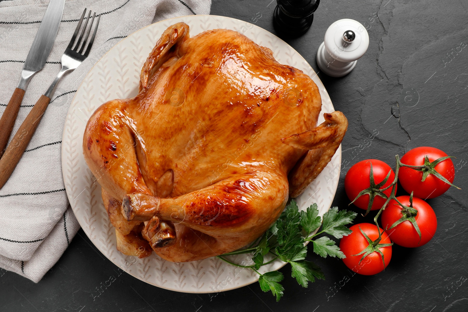 Photo of Tasty roasted chicken served on grey textured table, flat lay