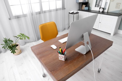 Photo of Comfortable workplace with computer on desk in home office