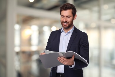 Image of Successful lawyer reading documents on blurred background