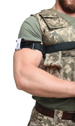 Soldier in military uniform applying medical tourniquet on arm against white background, closeup