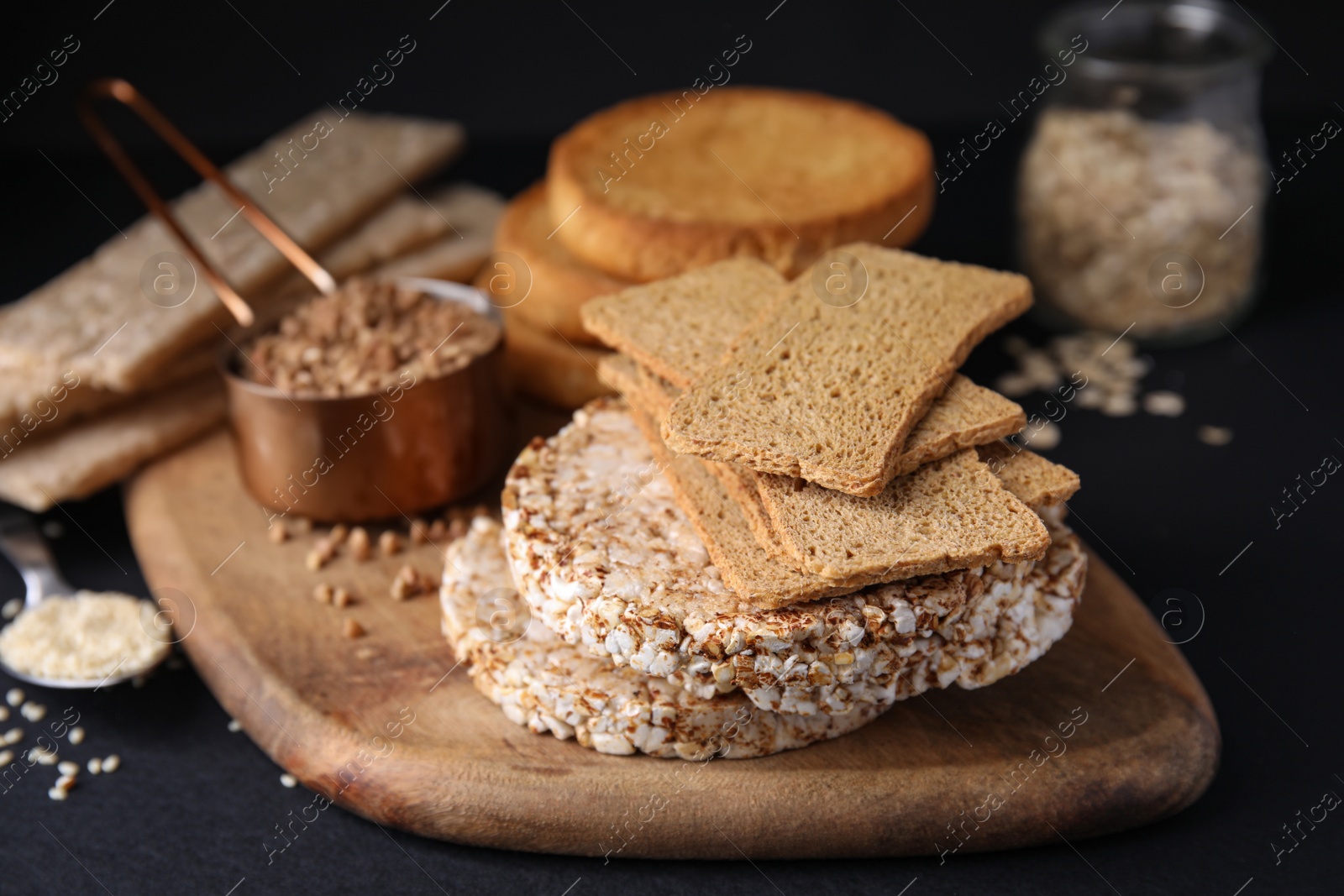 Photo of Rye crispbreads, rice cakes and rusks on black table