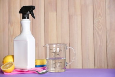 Photo of Composition with vinegar and cleaning supplies on table. Space for text