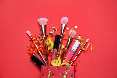 Photo of Flat lay composition with makeup products on red background