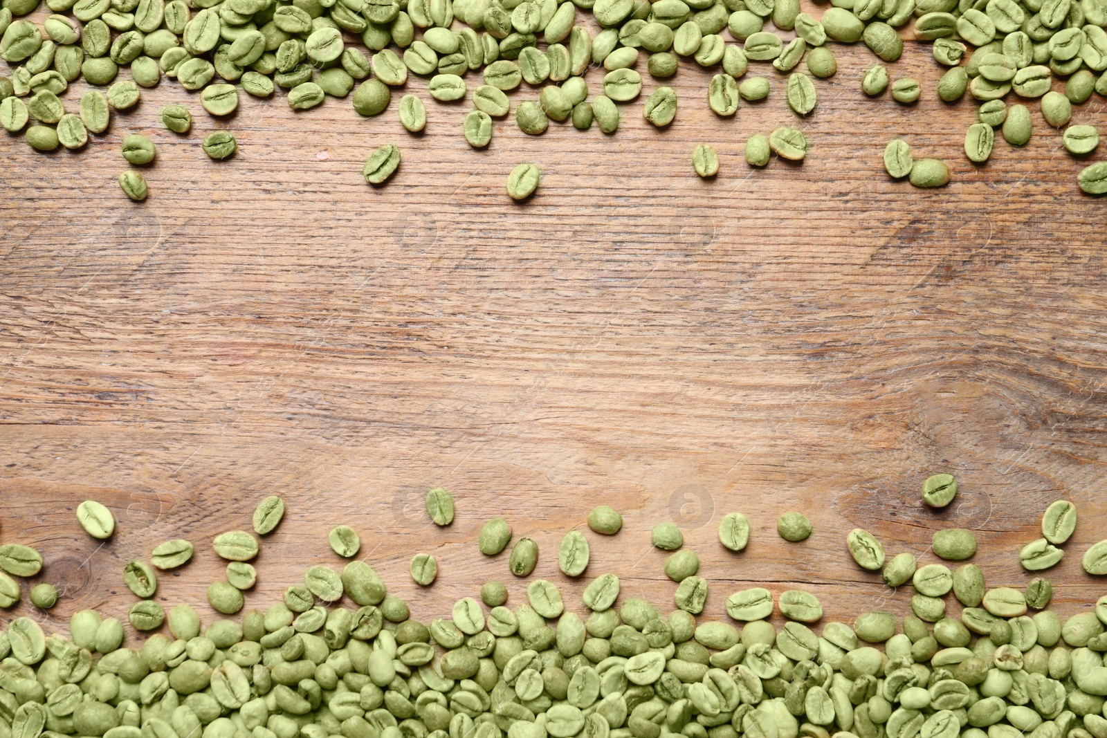 Photo of Many green coffee beans on wooden table, flat lay. Space for text