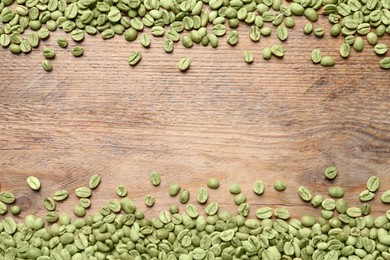 Many green coffee beans on wooden table, flat lay. Space for text