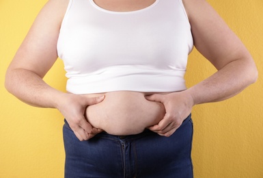 Photo of Overweight woman on color background, closeup. Obesity and weight loss