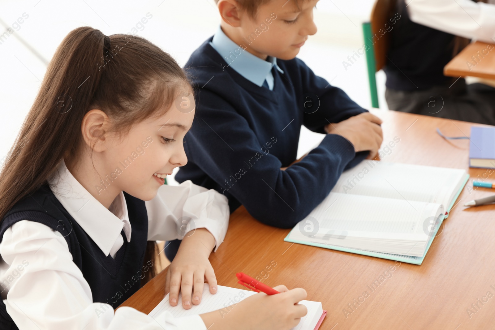 Photo of Little children in classroom. Stylish school uniform