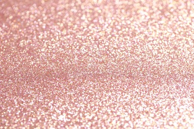 Photo of Beautiful rose gold shiny glitter as background, closeup