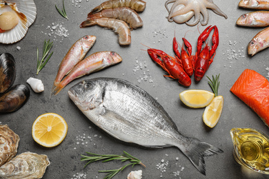 Photo of Fresh fish and seafood on grey table, flat lay