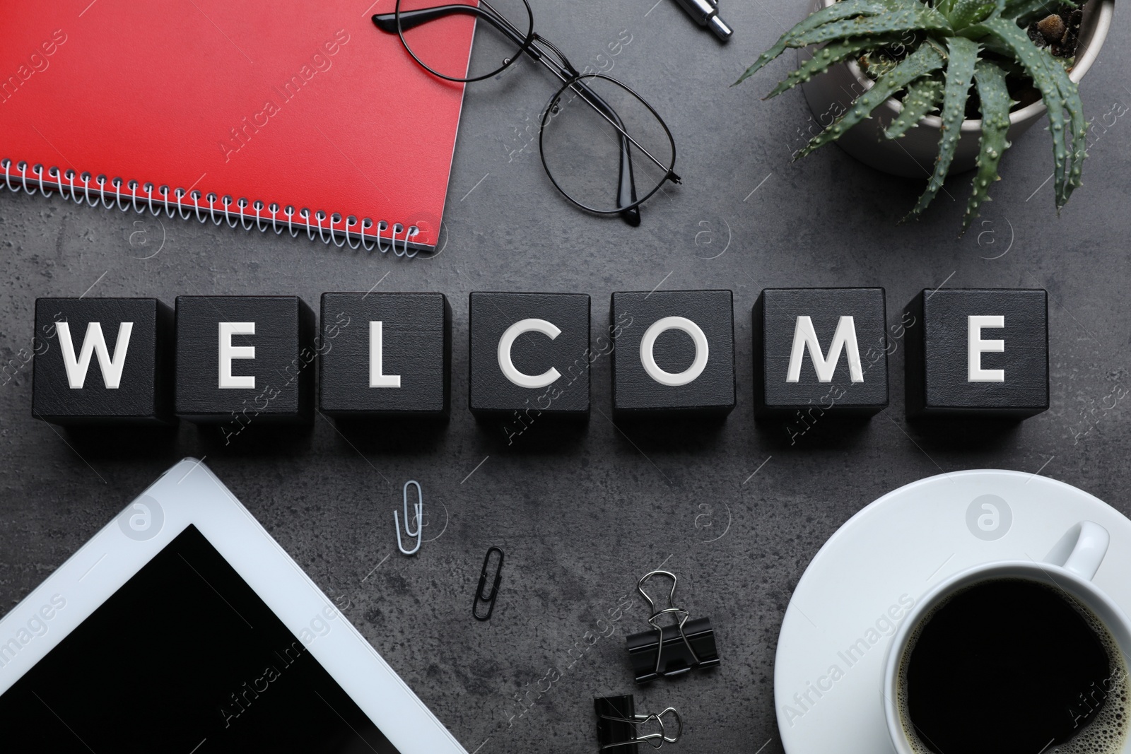 Photo of Flat lay composition of black cubes with word Welcome on grey table