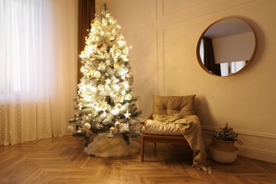 Beautiful decorated Christmas tree with skirt in room