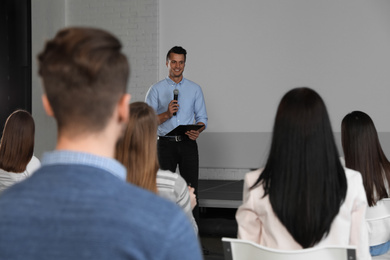 Male business trainer giving lecture in conference room with projection screen