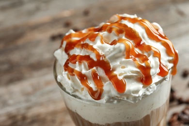 Photo of Glass of coffee with caramel topping on table, closeup