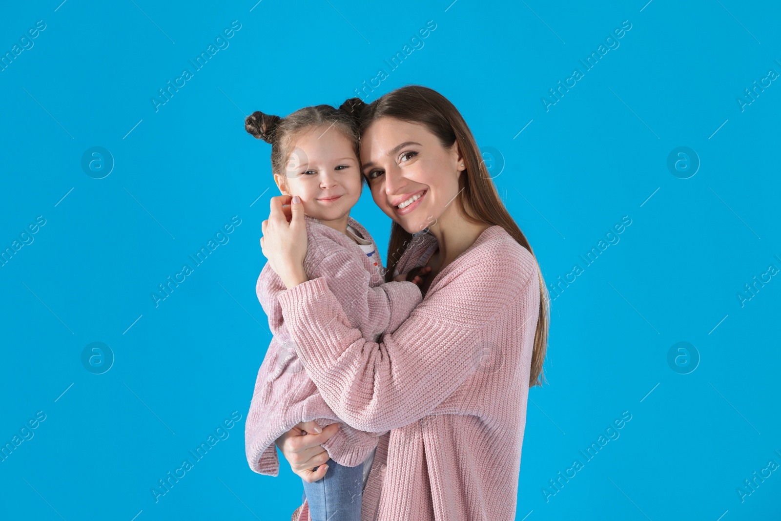 Photo of Young mother and little daughter on blue background