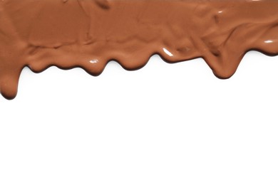 Tasty melted milk chocolate pouring down on white background