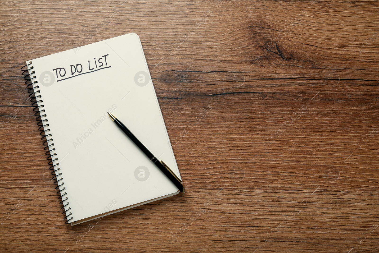 Photo of Notepad with inscription To Do List and pen on wooden table, top view. Space for text