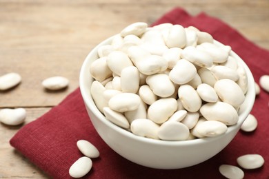 Raw white beans on wooden table, closeup