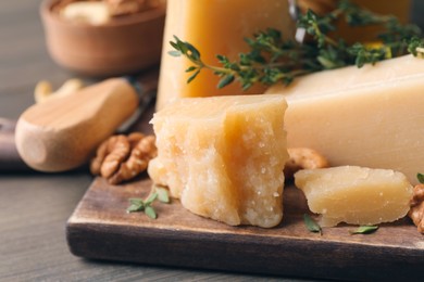 Photo of Delicious parmesan cheese on wooden board, closeup