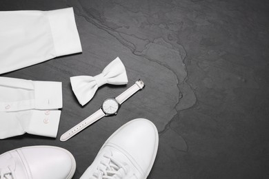 Photo of Stylish white bow tie, shoes, wristwatch and shirt on grey background, flat lay. Space for text
