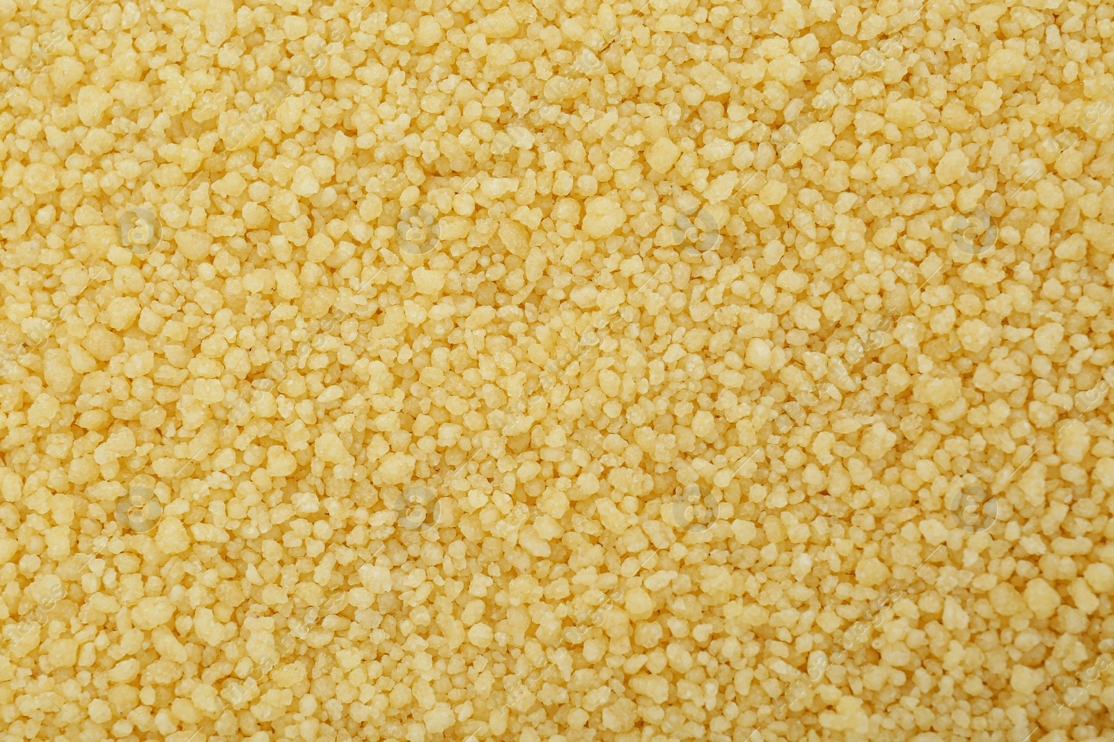 Photo of Raw couscous grains as background, top view