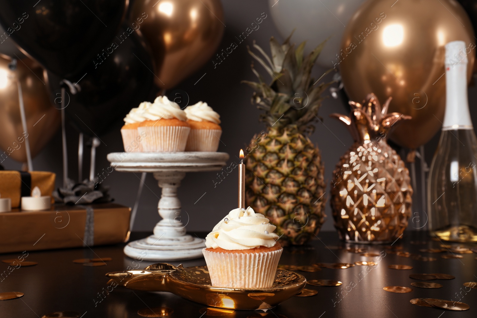Photo of Cupcake with candle and blurred balloons on background