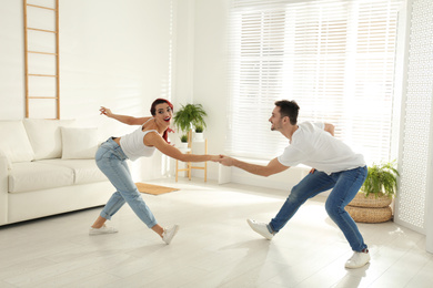 Photo of Beautiful young couple dancing in living room